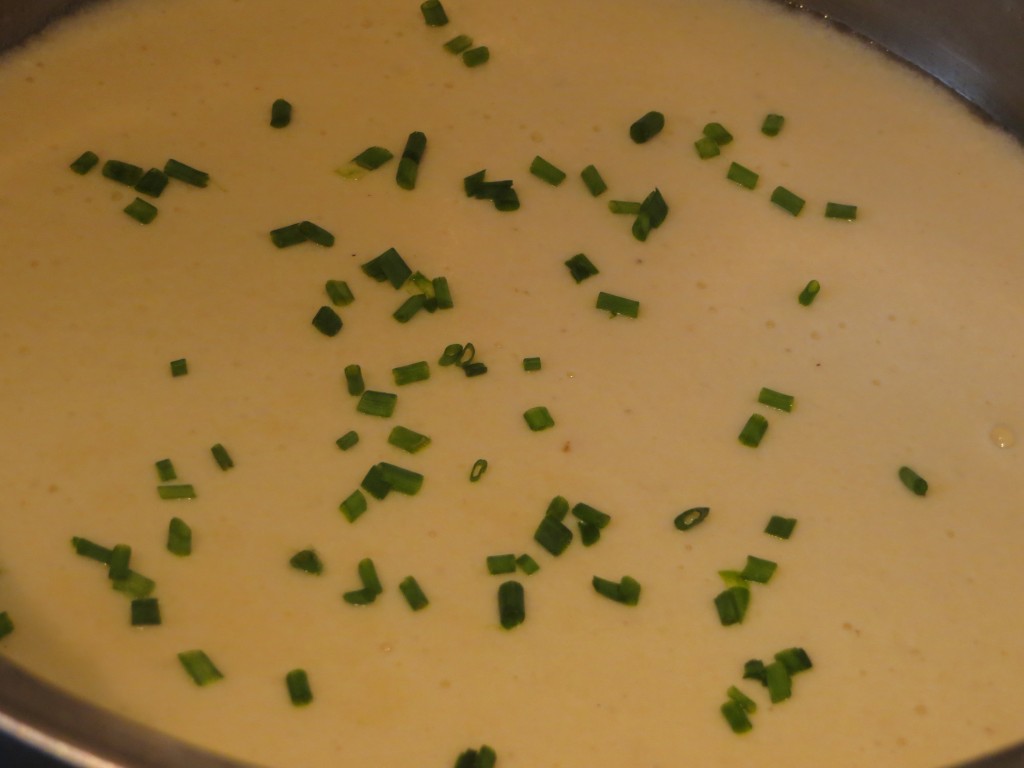 añadiendo cebollino a la salsa de queso roncal
