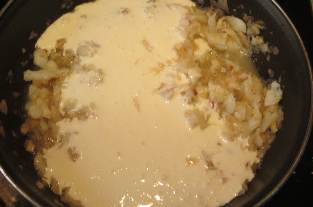 añadiendo la leche evaporada al pochado de cebolla y ajos