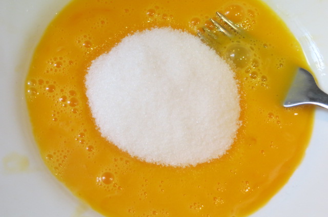 añadiendo azúcar blanco a las yemas de huevo