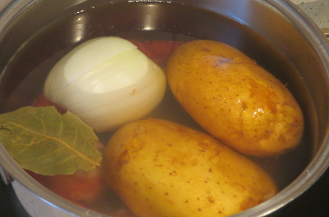 cociendo las patas de pulpo, las patatas y la cebolla 