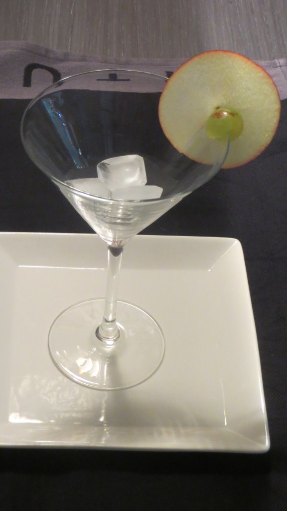 manzana y uva colocadas en el borde de la copa