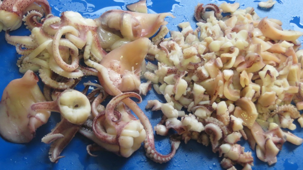 cortando las patas y aletas de los calamares