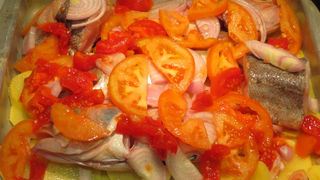 tomates y cebolla sobre los pescados