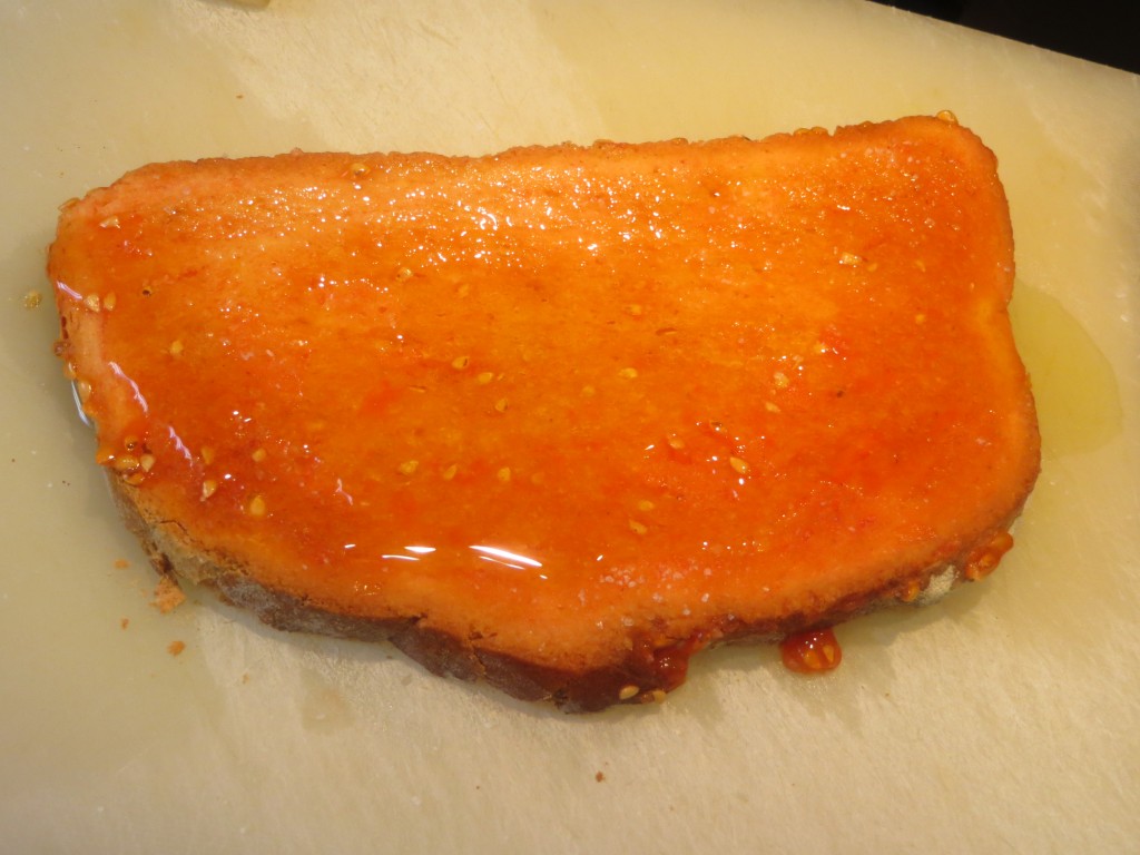 vertido de aceite sobre el pan con tomate