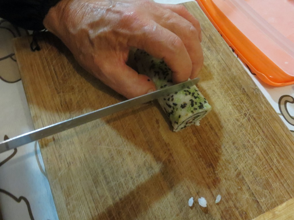 cortando el rollo de uramaki sushi