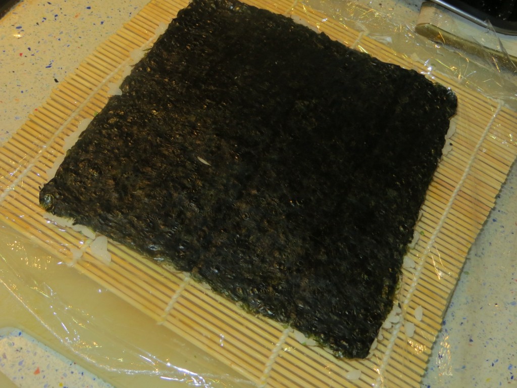 lámina de alga nori sobre la capa de arroz