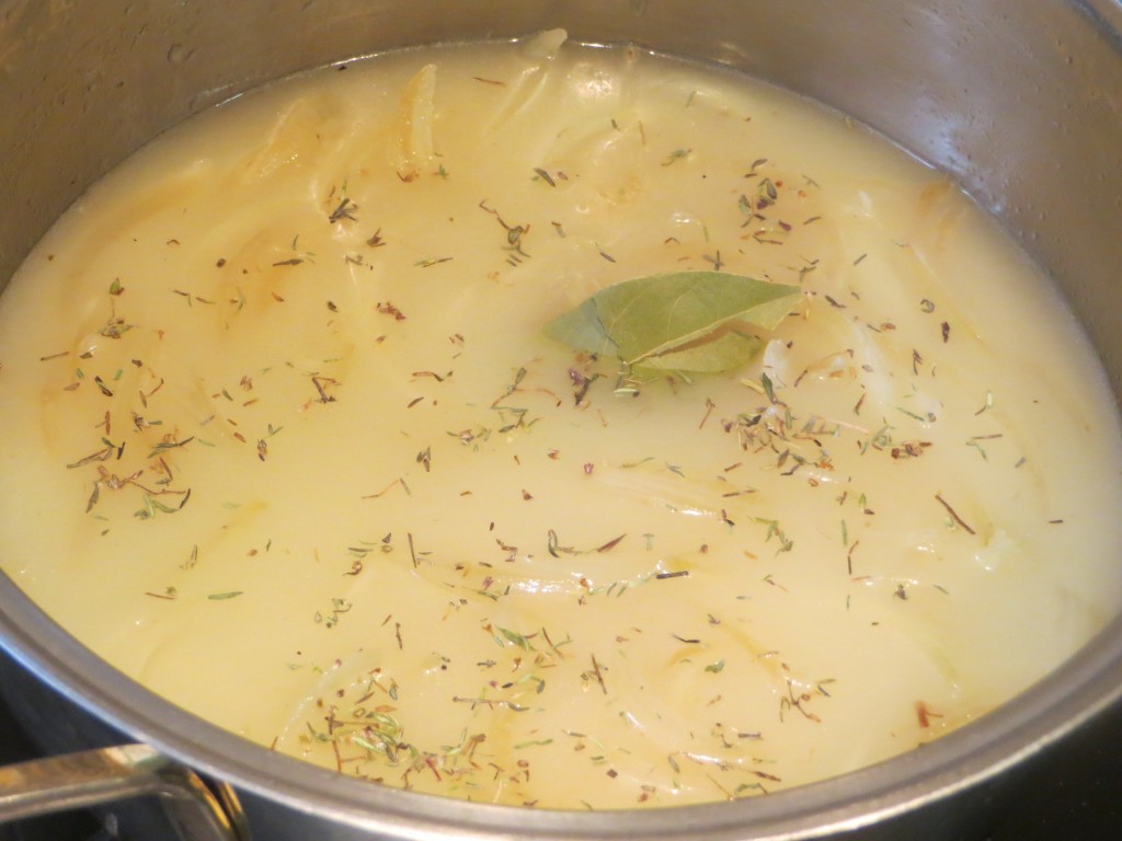 tomillo, caldo y laurel incorporados a la cebolla pochada