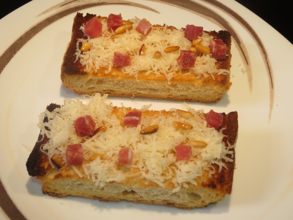 queso, jamón y piñones sobre la superficie del pan