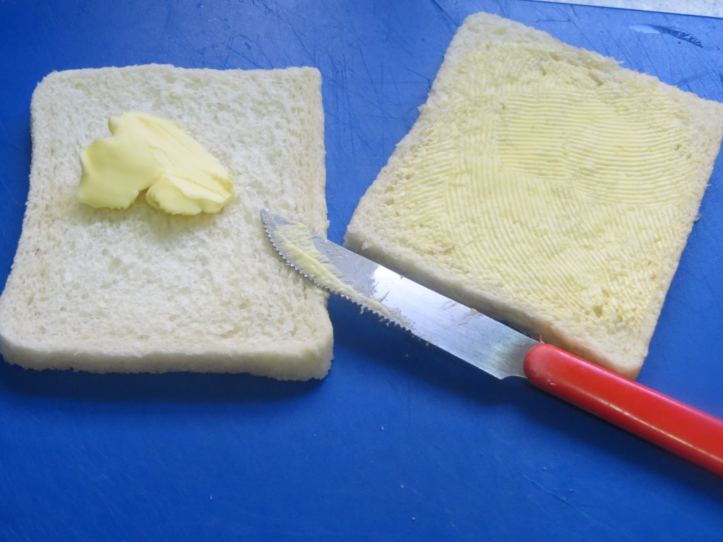 mantequilla extendida sobre la rebanada de pan