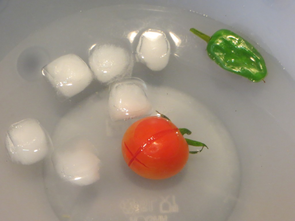 tomate cherry y pimiento de Padrón sumergidos en agua con hielo
